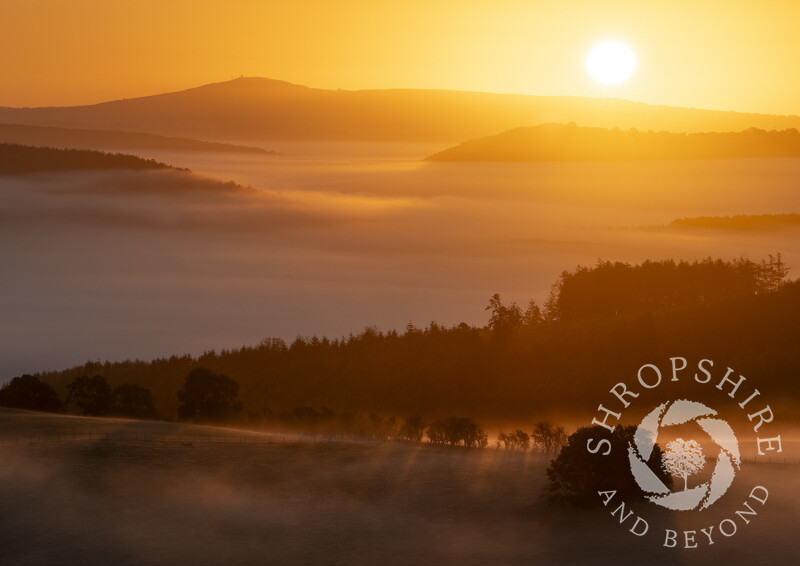 Misty sunrise over the Clun Valley seen from Bury Ditches, looking to Titterstone Clee, Shropshire.